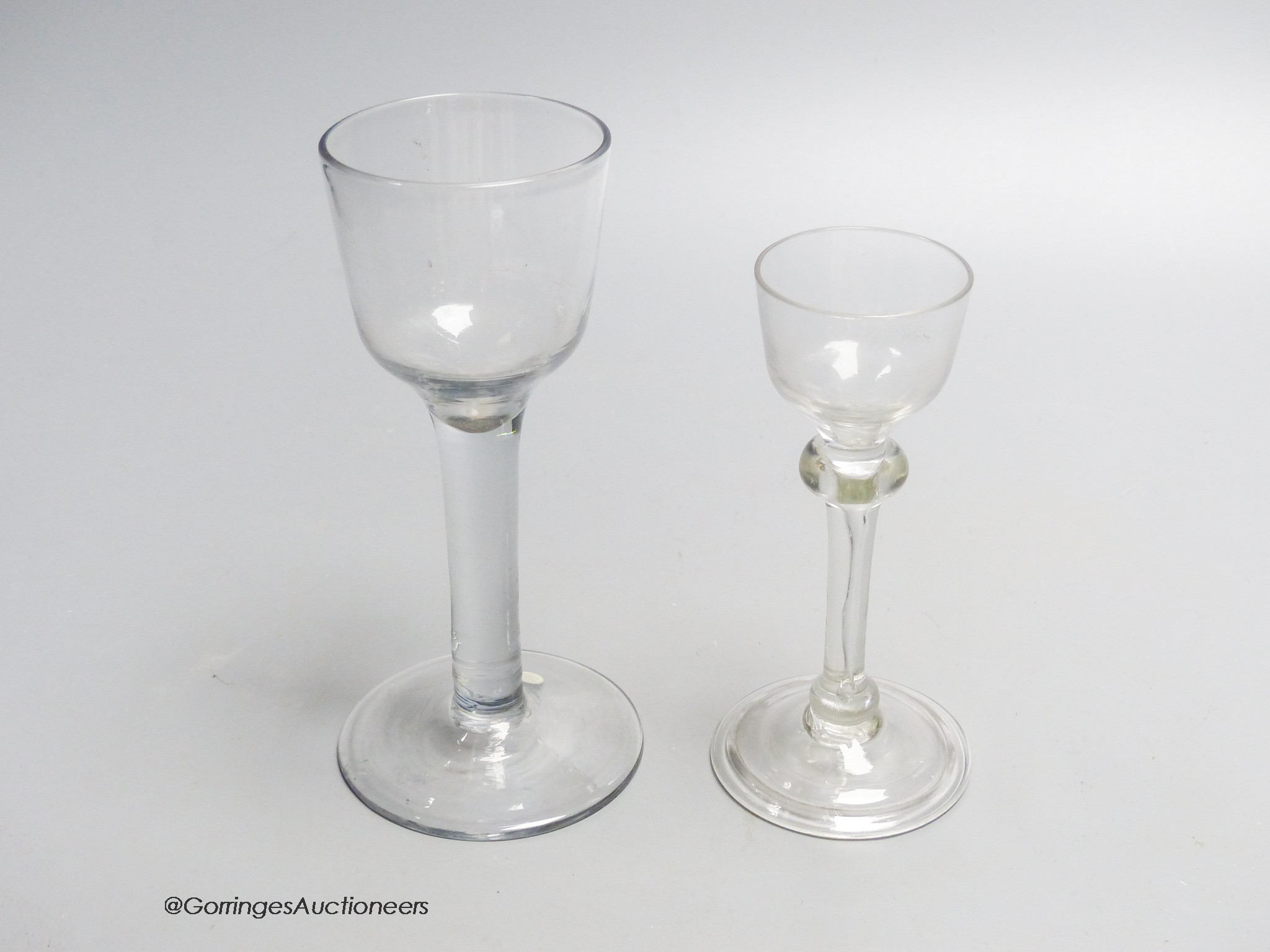Two Georgian drinking glasses including a light baluster type cordial glass and a plain stem wine glass, tallest 16.5cm